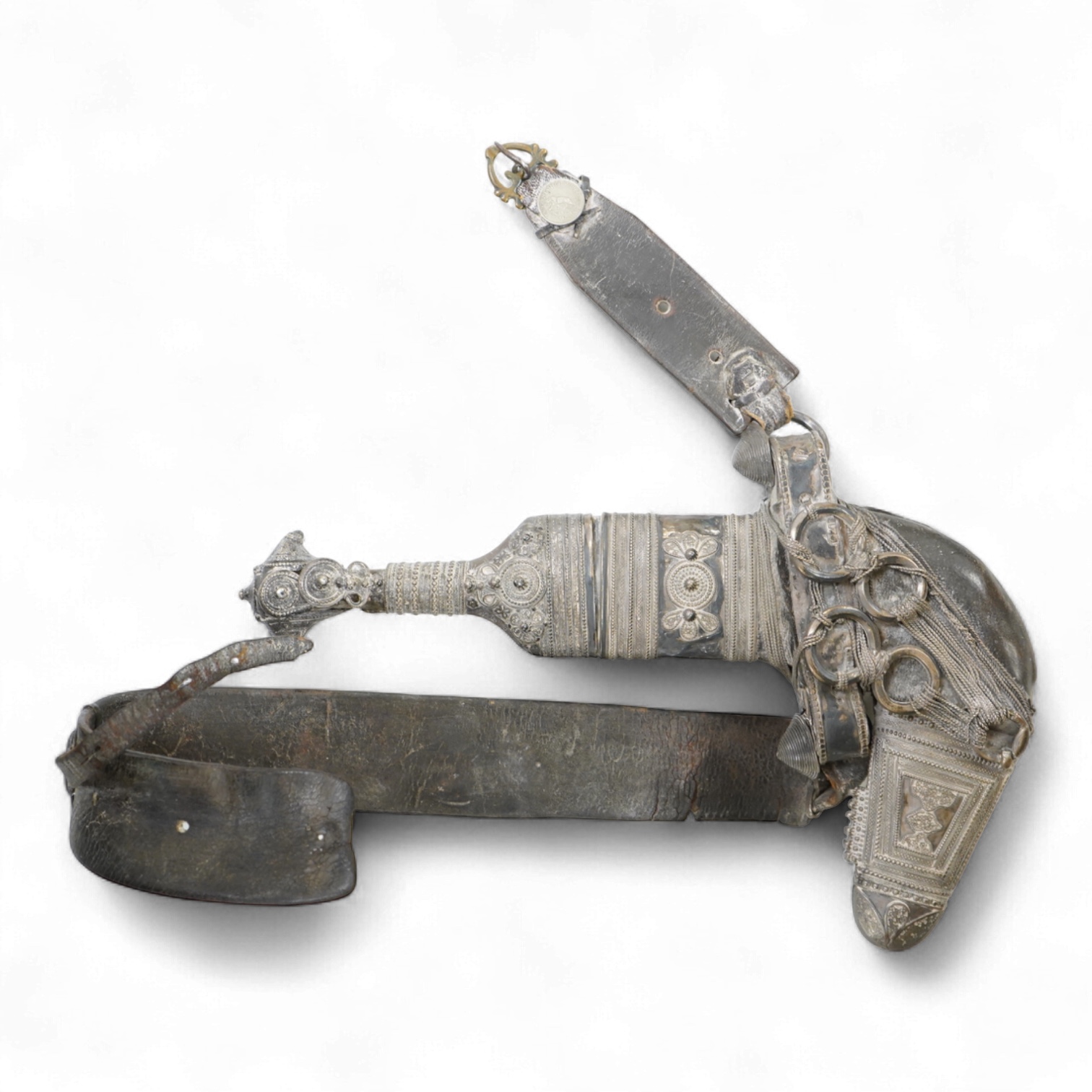A late 19th century Arab silver mounted dagger jambya with silver filigree mounts to hilt and sheath, in its leather covered scabbard with parts of the original belt